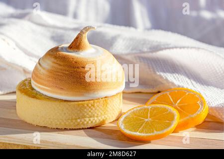 Yellow lemon tart with meringue and fresh lemons on the kitchen table background. Stock Photo