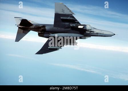 An underside view of an F-4E Phantom II aircraft of the 37th Tactical Fighter Wing flying over the Gulf of Mexico. Country: Unknown Stock Photo