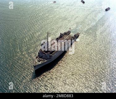 An aerial port bow view of the of French landing ship dock FS OURAGAN (L-9021), its stern gate open for landing craft operations, at sea during the NATO Southern Region exercise DRAGON HAMMER '90. Subject Operation/Series: DRAGON HAMMER '90 Country: Mediterranean Sea (MED) Stock Photo