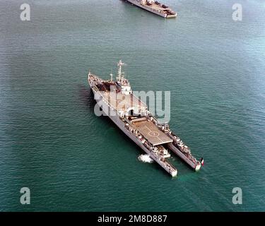 An aerial port quarter view of the of French landing ship dock FS OURAGAN (L-9021), its stern gate open for landing craft operations, at sea during the NATO Southern Region exercise DRAGON HAMMER '90. Subject Operation/Series: DRAGON HAMMER '90 Country: Mediterranean Sea (MED) Stock Photo