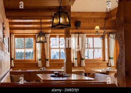 Part of a guest room with pendant lamps in a wooden house with a view of nature, Austria Stock Photo