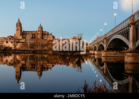 Scenic view of Salamanca with the Cathedral and iron bridge reflected in the Tormes River at sunset. Castilla Leon, Spain Stock Photo