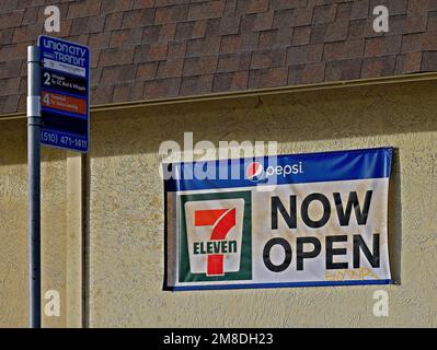 Seven Eleven store now open sign at a Union City Transit Bus Stop, California Stock Photo