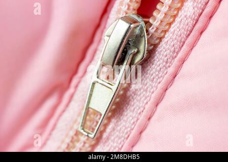Pink plastic zip fastener with metal detail close up. Stock Photo