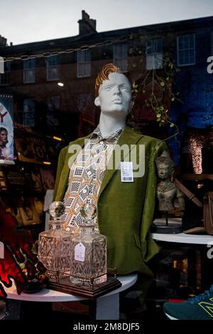 Mannequin and reflections in the window of a Shelter charity shop in Stockbridge, Edinburgh, Scotland, UK. Stock Photo