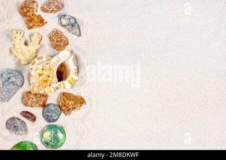 Yellow sandy textured background with bright seashells and stones as a frame with copy space top view. Sea holiday tourism and tropical vacations conc Stock Photo