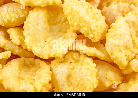 Bright yellow tasty sugar crunchy cornflakes for breakfast as a texture close up. Stock Photo