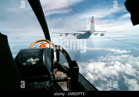 A view from inside the cockpit of a Fleet Composite Squadron 5 (VC-5)TA-4J Skyhawk aircraft as it is positioned for refueling from a Marine Refueler-Transport Squadron 152 (VMGR-152) KC-130F Hercules aircraft during exercise THALAY THAI '89. Subject Operation/Series: THALAY THAI '89 Country: Thailand (THA) Stock Photo