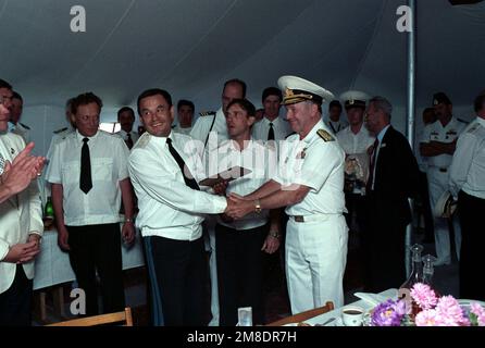 Wearing a Soviet admiral's cap, Vice Admiral John H. Fetterman Jr., Commander, Naval Air Force, US Pacific Fleet, shakes the hand of a Soviet rear admiral to whom he has presented a plaque. Fetterman is in the Soviet Union for a visit with two US Navy ships. The guided missile cruiser USS PRINCETON (CG-59) and the guided missile frigate USS REUBEN JAMES (FFG 57) are in Vladivostok for four days as part of a goodwill exchange program. Base: Vladivostok State: Siberia Country: U.S.S.R. (SUN) Stock Photo