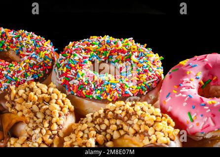 Sprinkled donuts closeup with black negative space ideal for website publication or menu Stock Photo