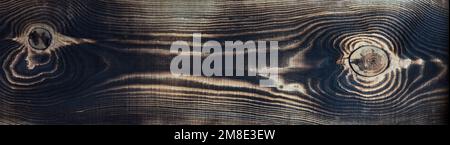 Burnt wood texture of a dark tone. Can be used as a natural background with copy space. Stock Photo