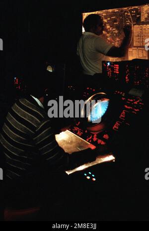 A technician monitors a radar screen as another marks the position of an aircraft on a plotting board in the Naval Research Laboratory (NRL) Identification Friend or Foe (IFF) Interrogator Station. The station's IFF equipment is used to challenge experimental equipment carried by aircraft flying from Naval Air Station, Patuxent River, Maryland, and may also interrogate all aircraft operating with Mark XII IFF and with the civil air traffic control radar beacon system. Base: Washington State: District Of Columbia (DC) Country: United States Of America (USA) Stock Photo