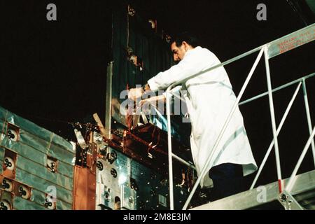 A technician at the Naval Research Laboratory (NRL) connects wires on the Low-power Atmospheric Compensation Experiment satellite, one of two major Strategic Defense Initiative (SDI) projects undertaken by the NRL. Base: Washington State: District Of Columbia (DC) Country: United States Of America (USA) Stock Photo