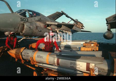 Aviation ordnancemen inspect an AIM-54C Phoenix missile on the flight deck of the aircraft carrier USS SARATOGA (CV-60) during Operation Desert Shield. An attack Squadron 35 (VA-35) A-6E Intruder aircraft is behind them. Subject Operation/Series: DESERT SHIELD Country: Unknown Stock Photo