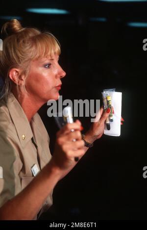 LT. CMDR. Alison Mueller briefs crew members of a U.S. Navy ship on the use of nerve gas antidote as the vessel is en route to the Middle East in support of Operation Desert Shield. Subject Operation/Series: DESERT SHIELD Country: Unknown Stock Photo