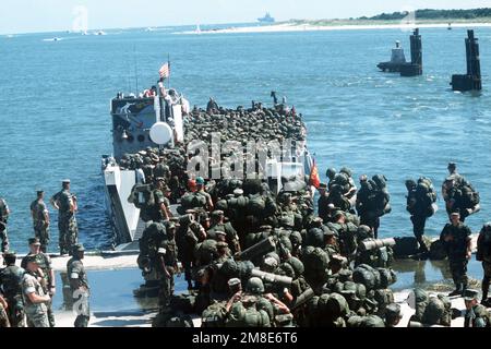 Marines board a utility landing craft for transportation to a ship offshore prior to departure for the Middle East in support of Operation DESERT SHIELD. Subject Operation/Series: DESERT SHIELD State: North Carolina (NC) Country: United States Of America (USA) Stock Photo