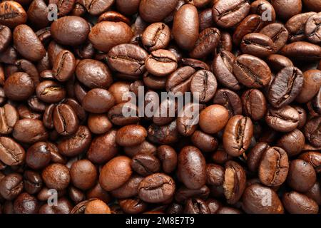 Close-up macro shot of the coffee beans lying on a flat surface. The photo shows the fine details and the texture of the product and can be used as a Stock Photo