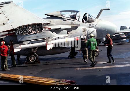 A bombardier/navigator from Attack Squadron 75 (VA-75) walks toward his A-6E Intruder aircraft aboard the aircraft carrier USS JOHN F. KENNEDY (CV-67) as preparations are made for the first air strikes of Operation Desert Storm. The aircraft is carrying two AGM-88 HARM high-speed anti-radiation missiles beneath its wing.. Subject Operation/Series: DESERT STORM Country: Red Sea Stock Photo