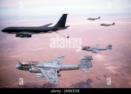 Two Tactical Electronic Warfare Squadron 130 (VAQ-130) EA-6B Prowler aircraft rendezvous with a KC-135E Stratotanker aircraft to refuel while en route to targets in Iraq during Operation Desert Storm. At upper right, a third Prowler aircraft is refueled by an Attack Squadron 75 (VA-75) A-6E Intruder aircraft carrying a 'buddy store' external fuel tank. VAQ-130 and VA-75 are based aboard the aircraft carrier USS JOHN F. KENNEDY (CV-67). Subject Operation/Series: DESERT STORM Country: Saudi Arabia (SAU) Stock Photo