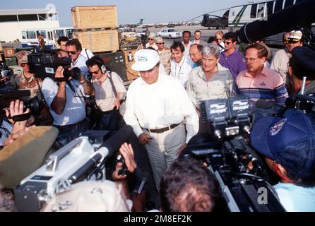 Media personnel crowd around Sen. Robert Dole of Kansas, center, Sen John Warner of Virginia, second from right, and Sen. Sam Nunn of Georgia, right, as they tour a military facility during Operation Desert Shield. Subject Operation/Series: DESERT SHIELD Country: Saudi Arabia (SAU) Stock Photo