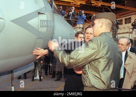 A Marine shows President George H.W. Bush an AV-8B Harrier aircraft while Secretary of the Navy H. Lawrence Garrett III looks on during a tour of the air station. Base: Mcas, Cherry Point State: North Carolina (NC) Country: United States Of America (USA) Stock Photo