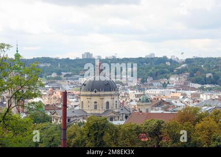 LVIV, UKRAINE - SEPTEMBER 11, 2022 Panorama view of the historical old city in Lviv, Ukraine. Many old buildings with metal roofs and cathedral domes in beginning of autumn day Stock Photo