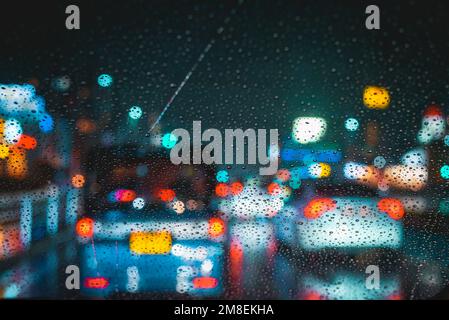 Raindrops on car windshield during night driving on a rainy evening traffic jam Stock Photo