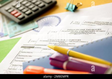 KYIV, UKRAINE - MAY 4, 2022 Indian income tax return blank form with pen and indian rupees bills on indian country flag close up. Annual tax report concept Stock Photo