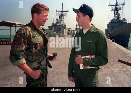 James Kelvin, British leading diver with the Royal Navy's logistic landing ship RFA Sir Galahad (L-3005), converses with Operations SPECIALIST 2nd Class (SW) John Lewis from the frigate USS VREELAND (FF-1068) during a port call, their first since the beginning of Operation Desert Storm. Subject Operation/Series: DESERT STORM Country: Saudi Arabia (SAU) Stock Photo