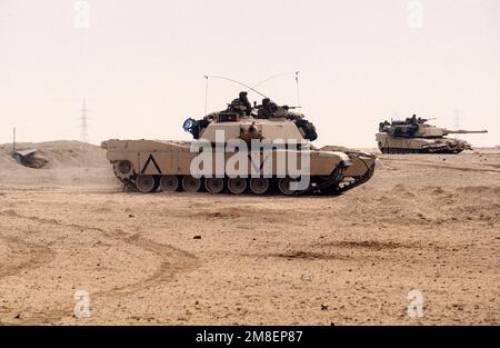 Two Marine Corps M-1A1 Abrams main battle tanks move across the desert ...