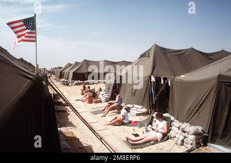 Off-duty nurses relax outside their tents at Fleet Hospital 15. The hospital was established to support Operation Desert Shield and Operation Desert Storm. Subject Operation/Series: DESERT SHIELD DESERT STORM Country: Saudi Arabia (SAU) Stock Photo