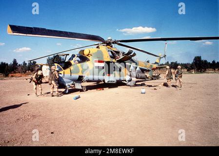 Members of the 82nd Airborne Division inspect a captured Iraqi Mil Mi-24 helicopter gunship armed with two 57mm S-5 rocket pods and an AT-2 Swatter anti-tank missile on the wing tip pylon during Operation Desert Storm.. Subject Operation/Series: DESERT STORM Country: Unknown Stock Photo