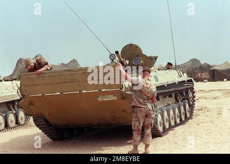 Two Marines lower the trim vane on the front of an Iraqi BMP-1 mechanized infantry combat vehicle that was captured during Operation Desert Storm. Subject Operation/Series: DESERT STORM Country: Kuwait (KWT) Stock Photo