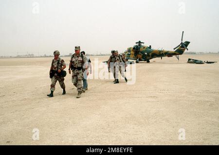 GEN. Norman Schwarzkopf, commander-in-chief, U.S. Central Command, and LT. GEN. Gary Luck, commander, XVIII Airborne Corps, walk across the airfield after inspecting an Iraqi MIL Mi-24 Hind helicopter captured during Operation Desert Storm. The aircraft is on the airfield at the XVIII Airborne Corps base of operations at Rahfa Airport.. Subject Operation/Series: DESERT STORM Country: Saudi Arabia(SAU) Stock Photo