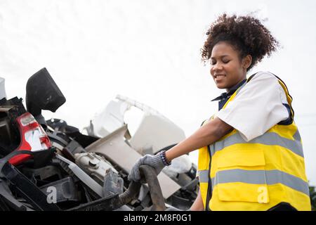 Mechanical woman owner small business inspecting standing in the car junkyard, Dirty male repairman choosing spare parts on car junkyard, Used of vehi Stock Photo