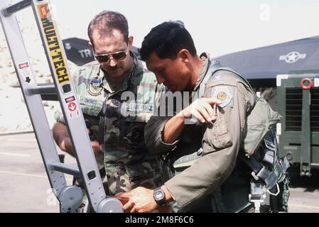 In preparation for the flight home after Operation Desert Storm, F-117A stealth fighter aircraft pilot MAJ. Joe Bowley and crew chief STAFF SGT. David Owings of the 37th Tactical Fighter Wing review the pre-flight checklist.. Subject Operation/Series: DESERT STORM REDEPLOYMENT Country: Saudi Arabia(SAU) Stock Photo