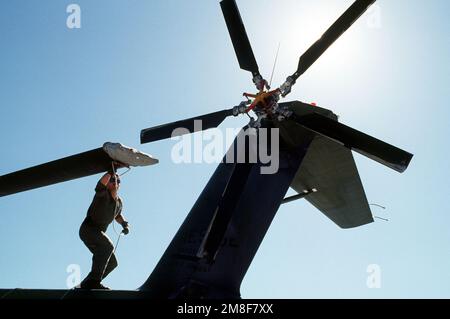 SSGT Wayne C. Giffen, flight engineer, 71st Air Rescue Squadron (71st ARS), prepares to anchor tail rotor blades on an HH-3E Jolly Green Giant helicopter as the HH-3E is secured for the night. The helicopter is stopping over at Malmstorm en route to Aircraft Maintenance and Regeneration Center at Davis-Monthan Air Force Base, Arizona, where the HH-3E is being relocated in preparation for the squadron's deactivation on June 1, 1991. The 210th Rescue Squadron, Air National Guard, will take over Alaskan rescue missions. Base: Malstrom Air Force Base State: Montana(MT) Country: United States Of Am Stock Photo