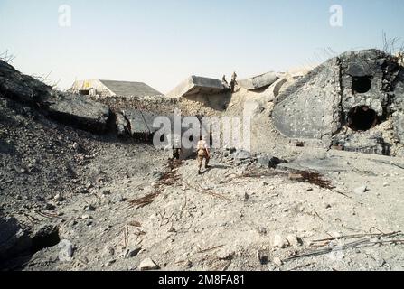 U.S. soldiers inspect a hardened aircraft shelter destroyed by Coalition forces during Operation Desert Storm. The air base was held by Iraqi forces during their occupation of Kuwait.. Subject Operation/Series: DESERT STORM Base: Ali Al Salem Air Base Country: Kuwait(KWT) Stock Photo