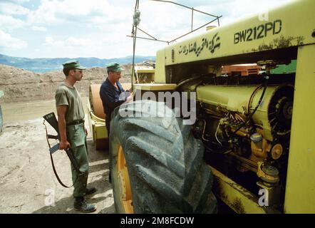 PETTY Officer 2nd Class Ken W. Shade, left, and PETTY Officer 1ST Class Russ Leinbach, Seabees from Naval Mobile Construction Battalion 133 (NMCB-133), examine a motorized roller left behind at an airfield by Iraqi workers. The airfield, which had been under construction prior to the start of the Persian Gulf war, is being repaired to allow relief supplies to be flown in for nearby Kurdish refugees as part of Operation Provide Comfort. Subject Operation/Series: PROVIDE COMFORT Base: Sirsenk Country: Iraq (IRQ) Stock Photo