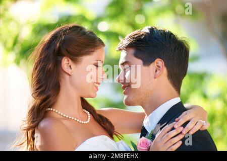 They cant wait for the honeymoon. Head and shoulders shot of a couple of newlyweds looking at each other affectionately. Stock Photo