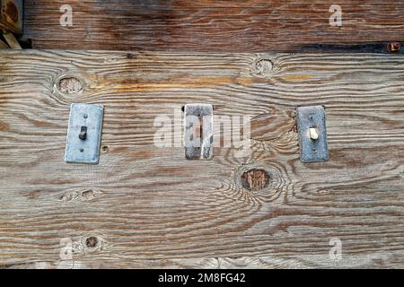 Vintage electrical switches haphazardly attached to a wooden board Stock Photo