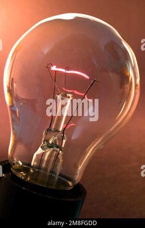 A lamp bulb and a  fluorescent tungsten spiral showing the presence of electric energy Stock Photo