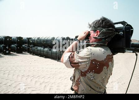 A video cameraman films operations as ordnance and equipment is loaded ...