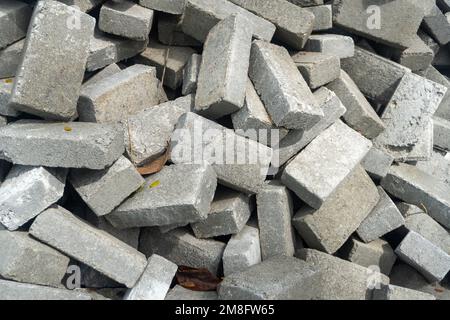 Pile of gray concrete bricks in the middle of a city park construction close up Stock Photo
