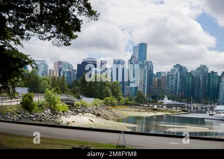 North Vancouver - mountains, bay, Cargo warehouse - industrial port, cargo ship. beautiful clouds and the sea. Travel in the summer. Stock Photo