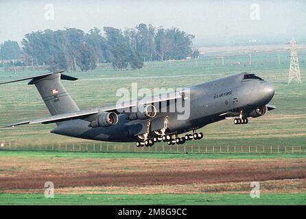 A right side view of a 75th Airlift Squadron (75th AS) C-5B Galaxy aircraft landing on base. Base: Travis Air Force Base State: California (CA) Country: United States Of America (USA) Stock Photo