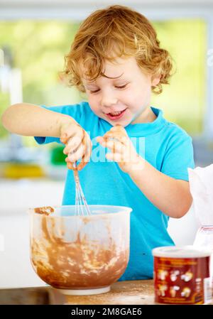 The future of the culinary arts. A little boy covered in dough and flour. Stock Photo