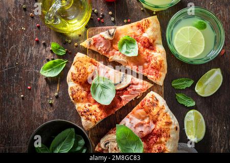 Hot Capricciosa pizza made of ham and mushrooms. Italian pizza. Capricciosa pizza with ham, cheese and mushrooms. Stock Photo