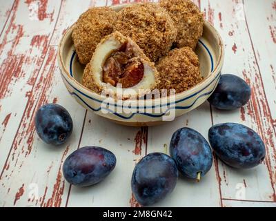 The plum dumplings served on a bowl on the wooden table Stock Photo