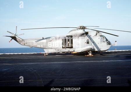 A crewman sits in the door of a Helicopter Anti-submarine Squadron 9 (HS-9) SH-3H Sea King helicopter during flight operations on the aircraft carrier USS SARATOGA (CV-60). Country: Mediterranean Sea (MED) Stock Photo